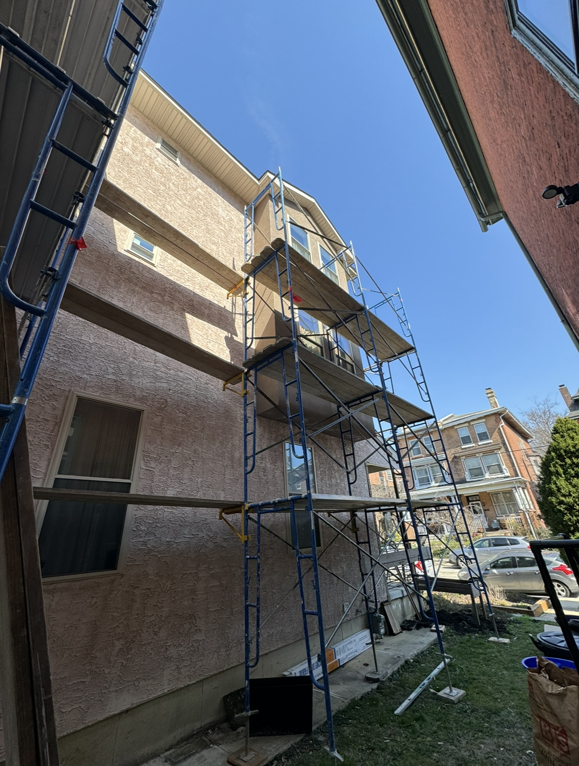 A building with scaffolding on the side of it is being painted.