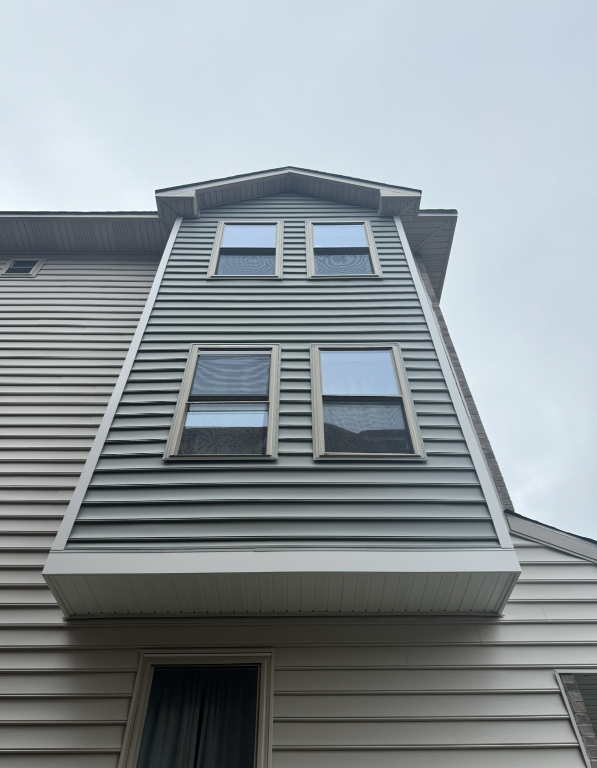 A house with a balcony on the side of it and a lot of windows.