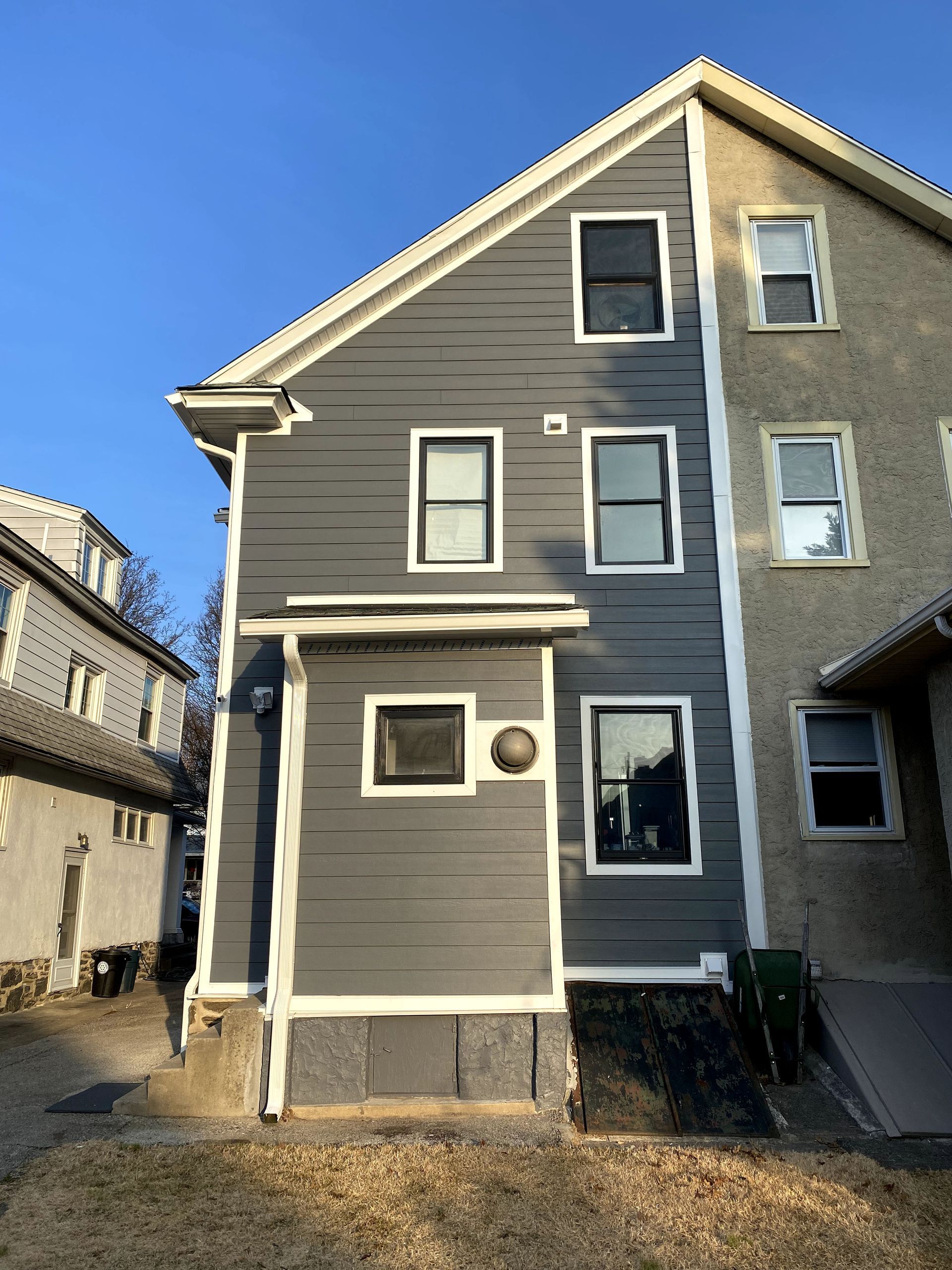 A house with a lot of windows and a blue sky in the background