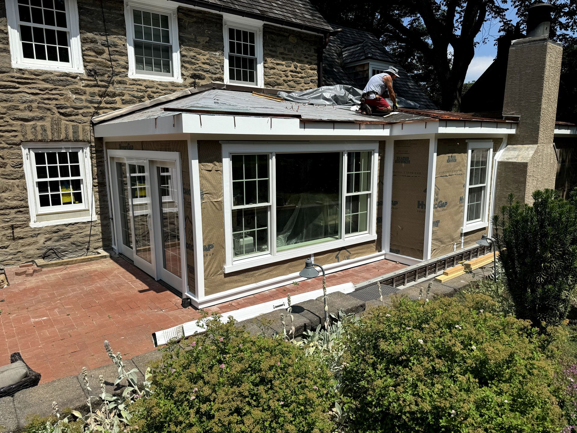 A man is working on the roof of a house.