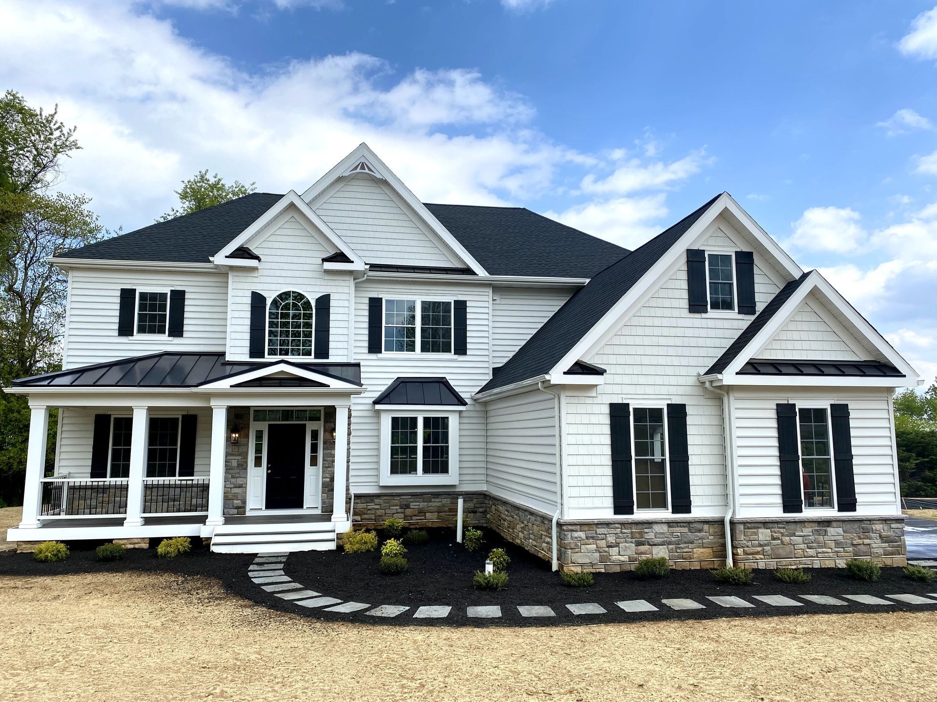 A large white house with a black roof and black shutters