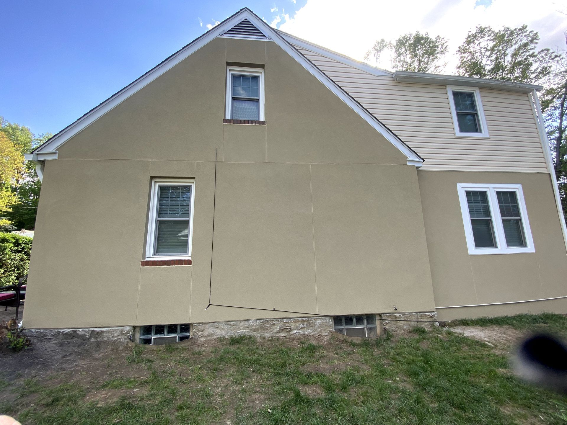A house with a lot of windows and a blue sky in the background