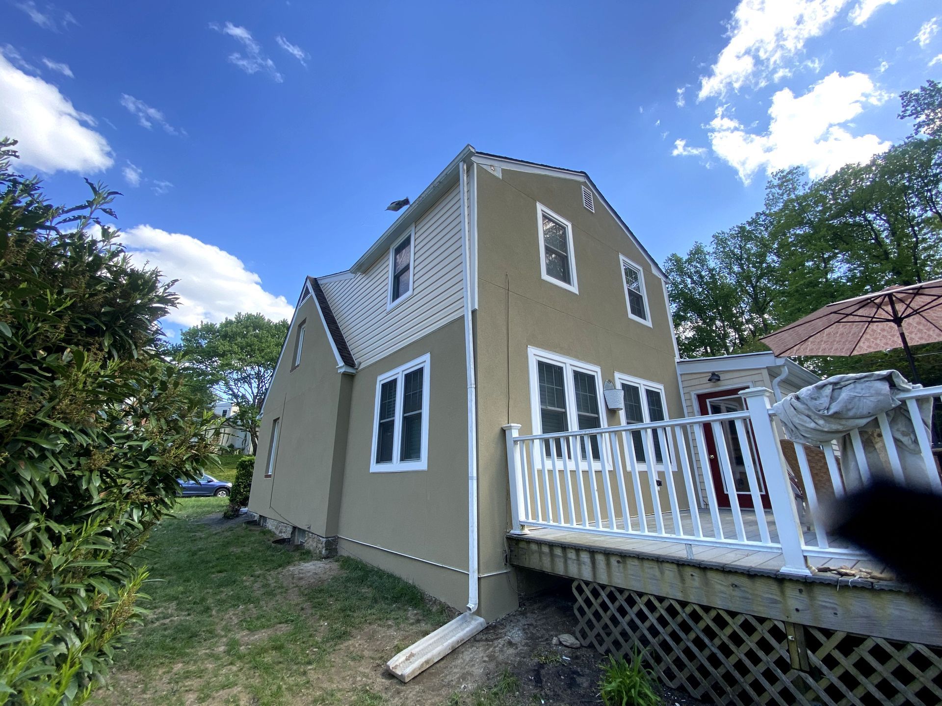 A house with a deck and a blue sky in the background.