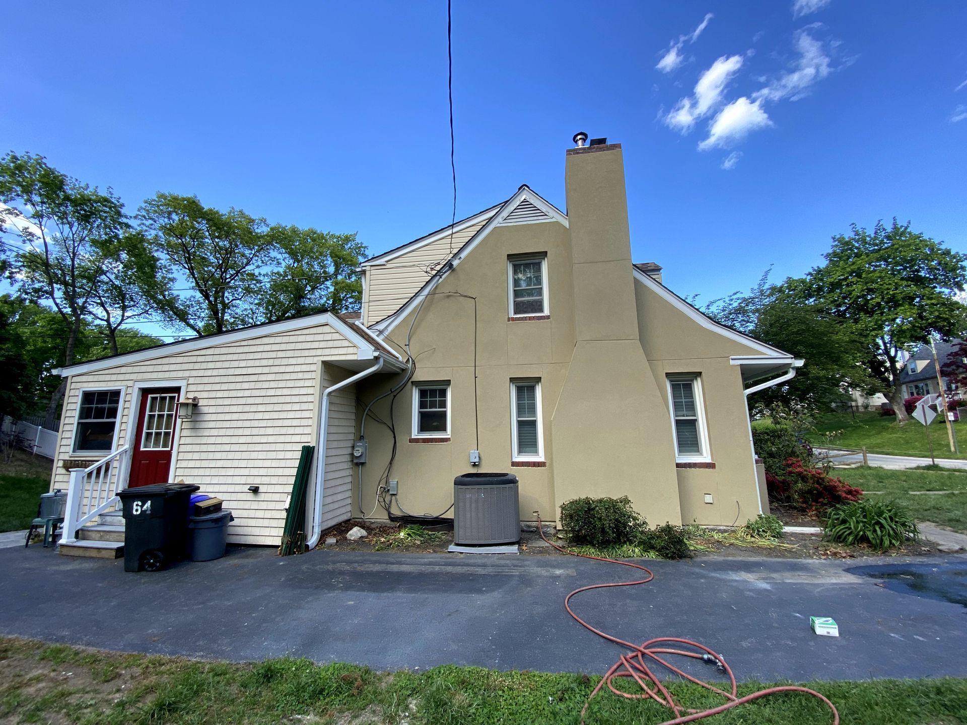 A house with a chimney and a hose in front of it