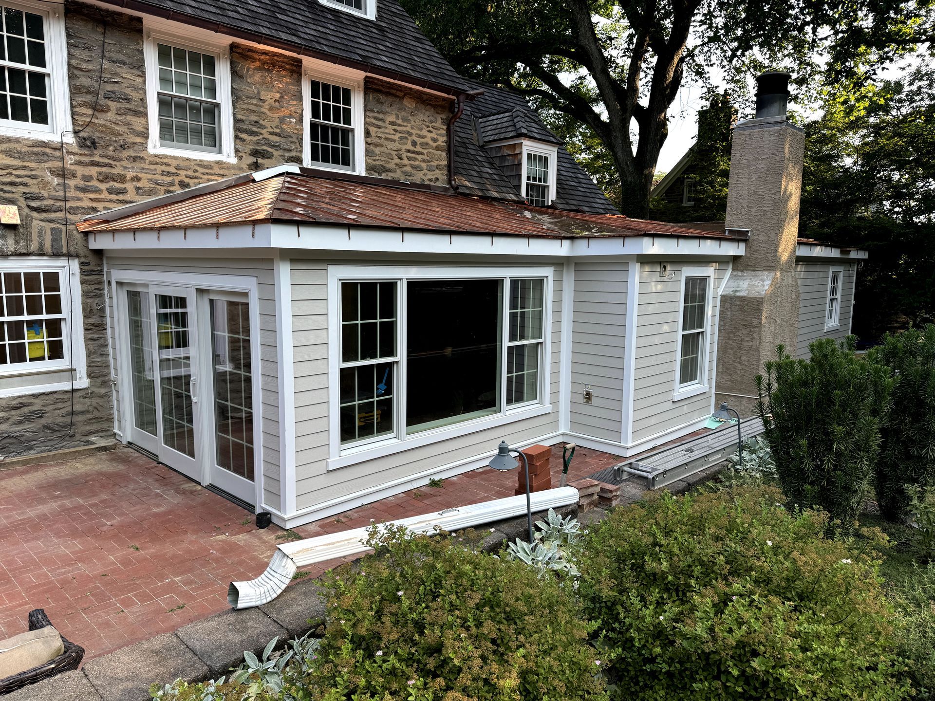 A house with a large window and a patio in front of it.