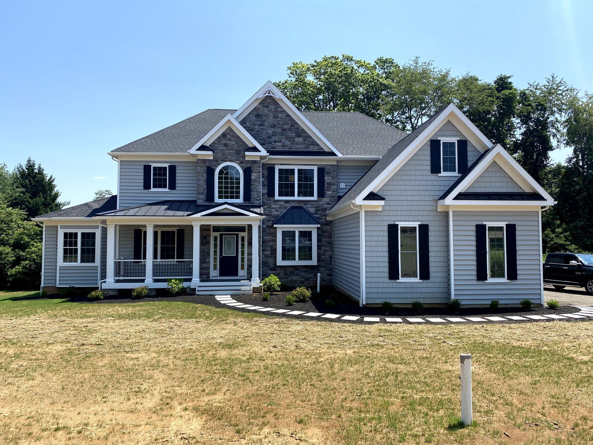 A large white house with black shutters and a large porch