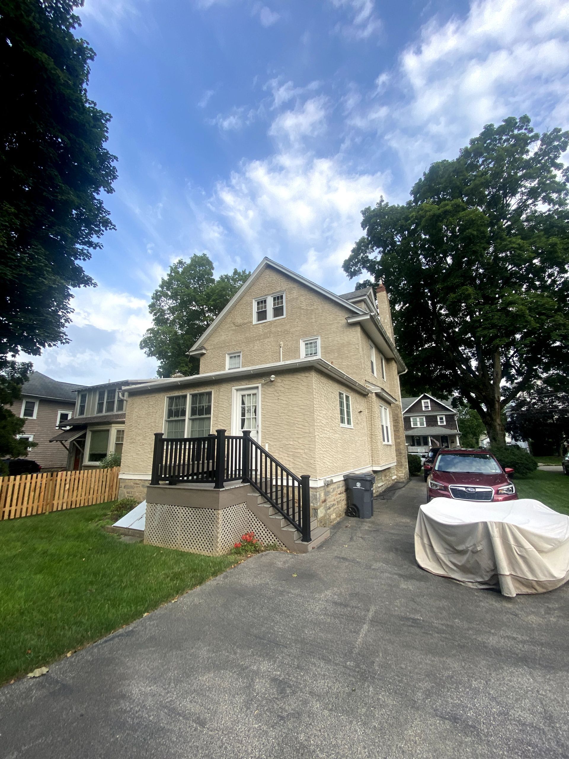 A large brick house with a red car parked in front of it.