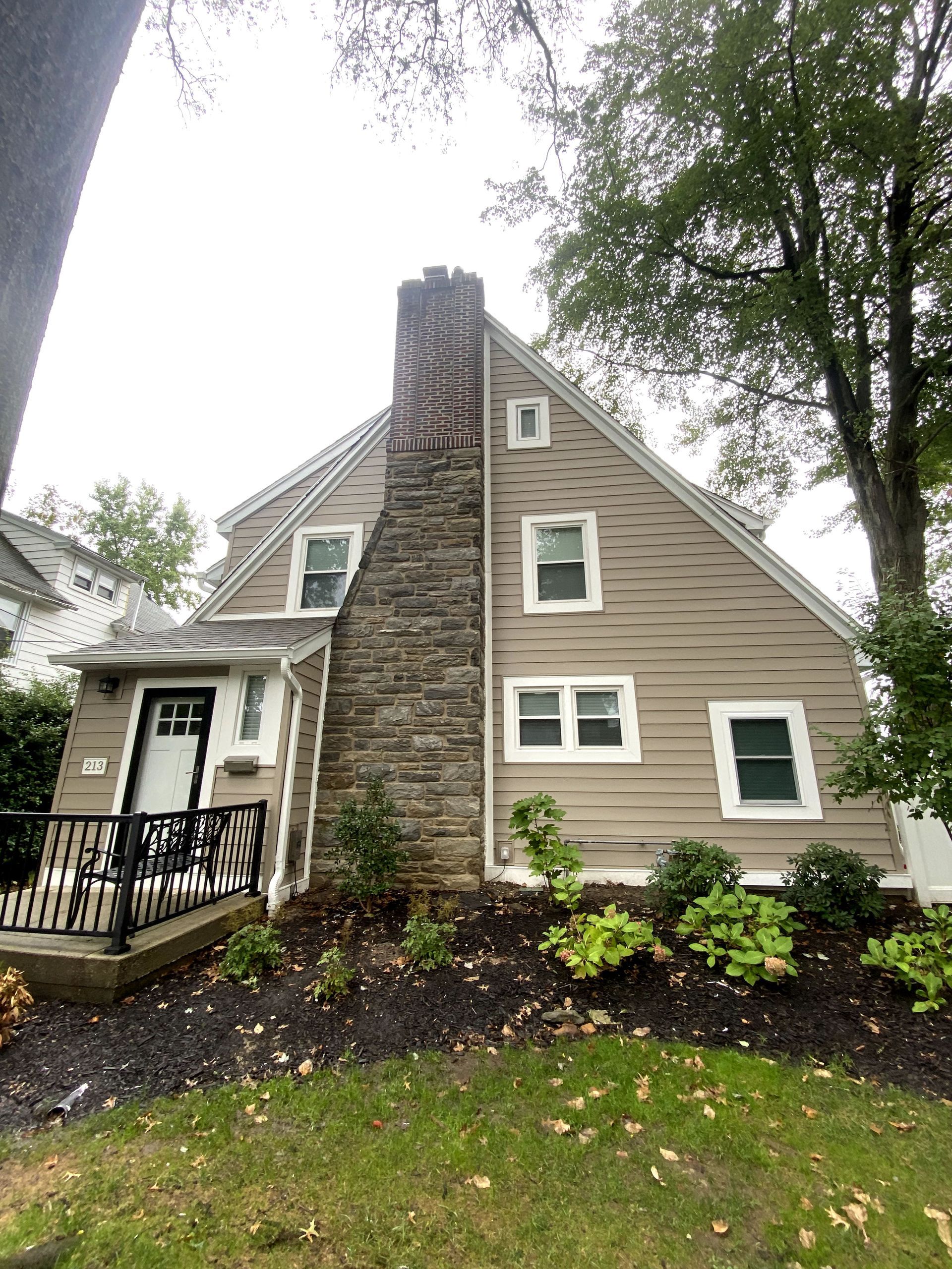 A house with a stone chimney on the side of it.