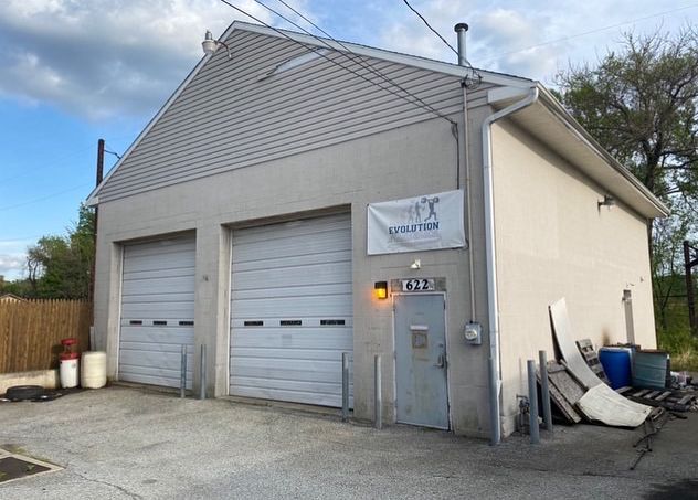 A large white house with stairs leading up to the second floor