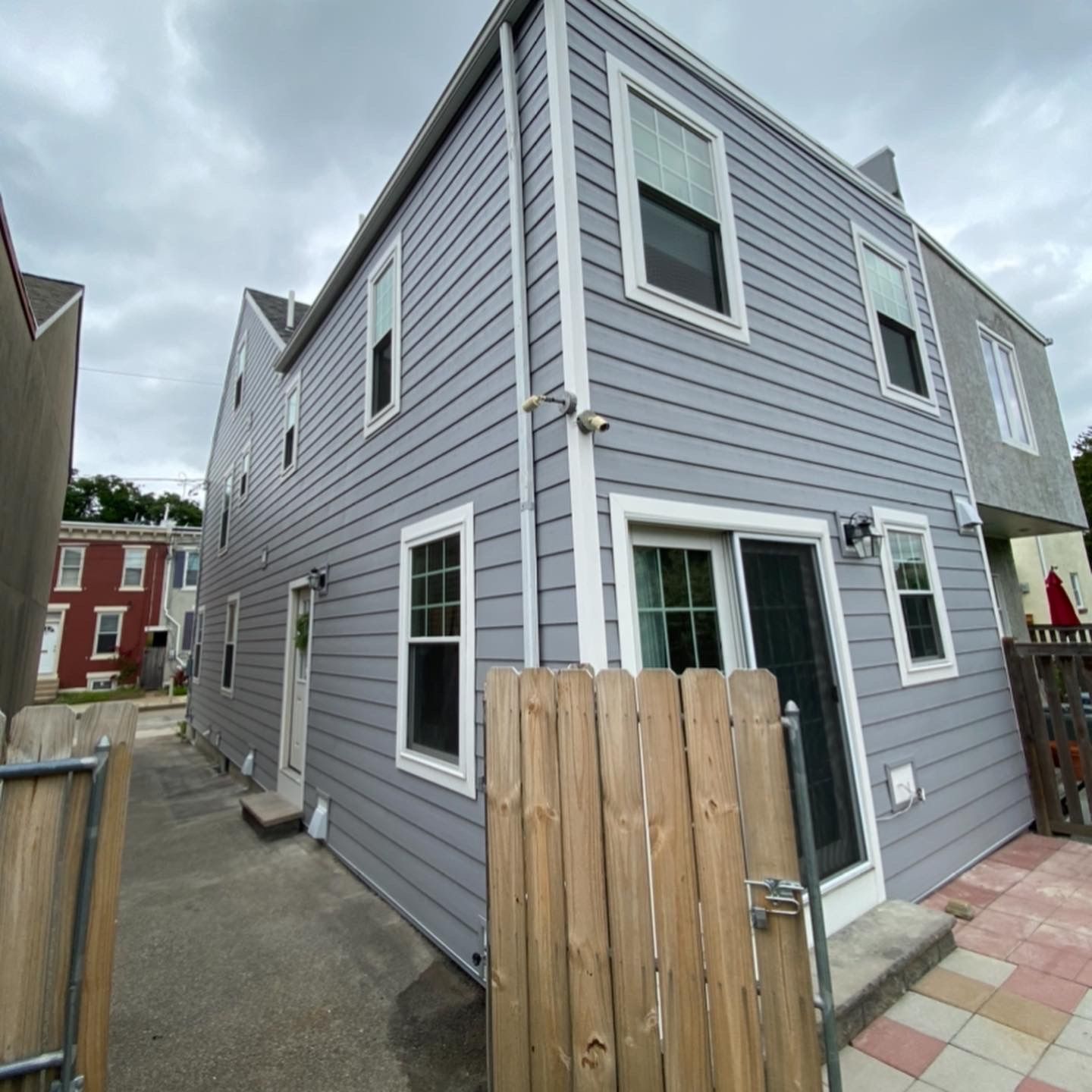 A gray house with a wooden fence in front of it