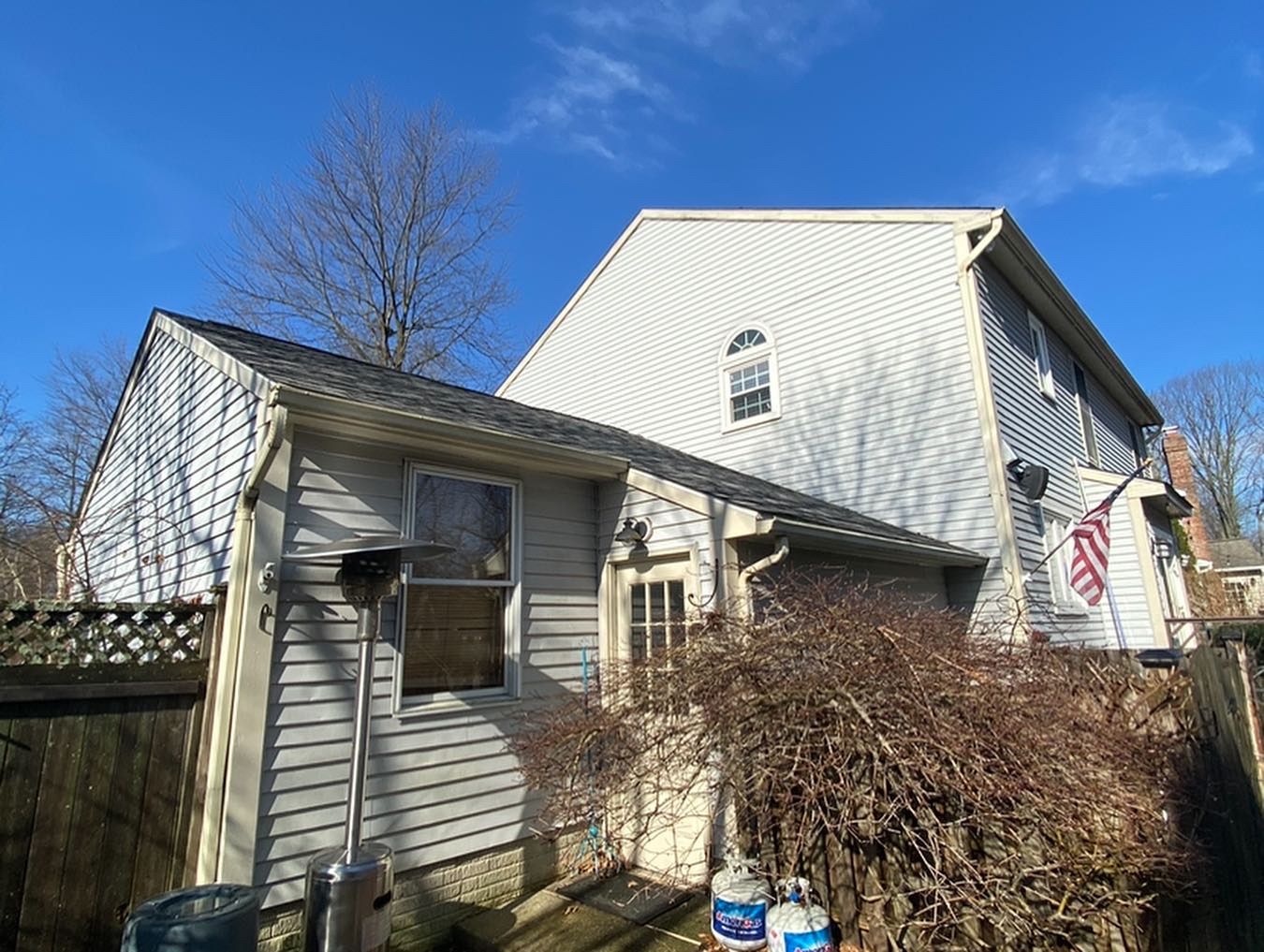 The back of a house with a flag on the side of it.