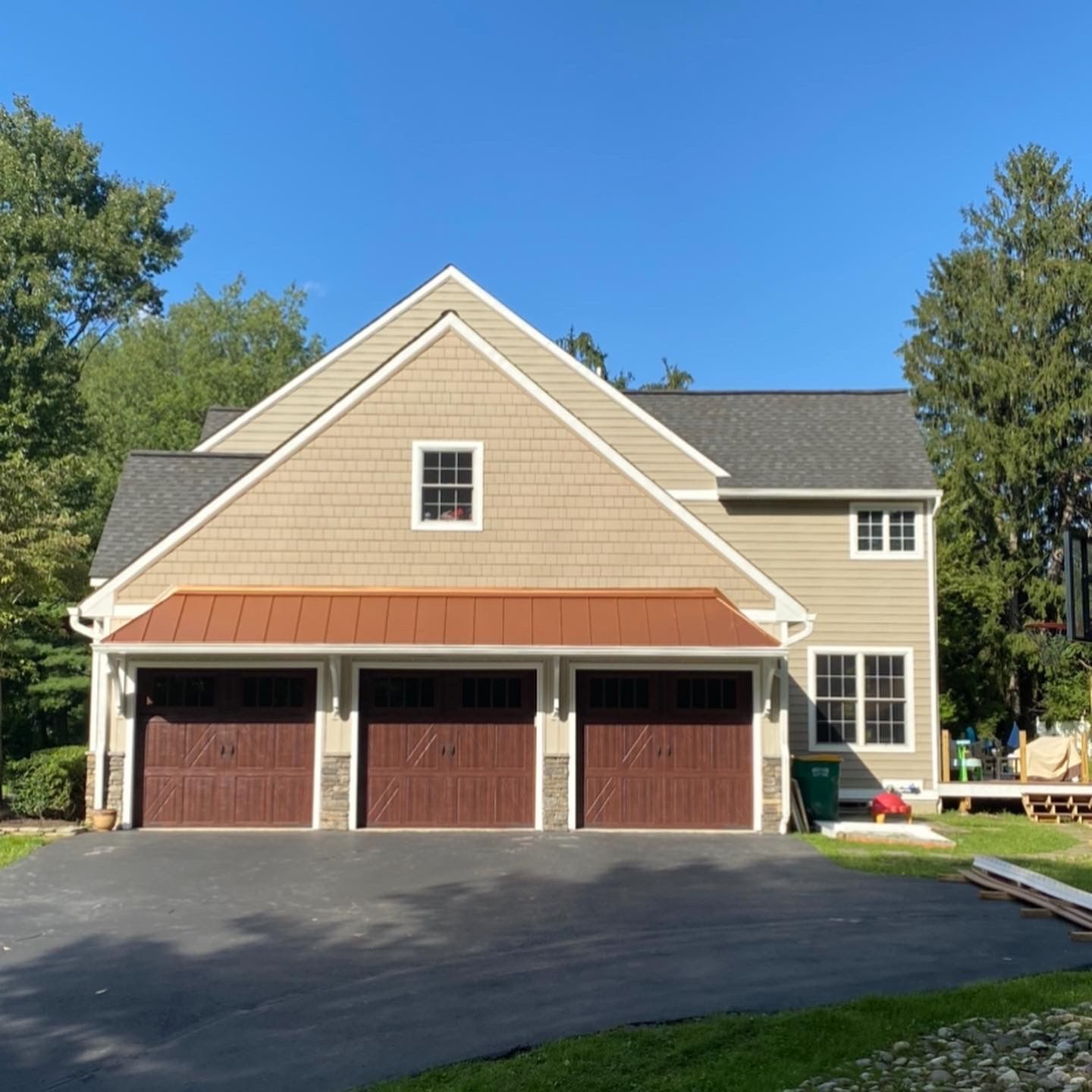 A large house with three garage doors and a driveway