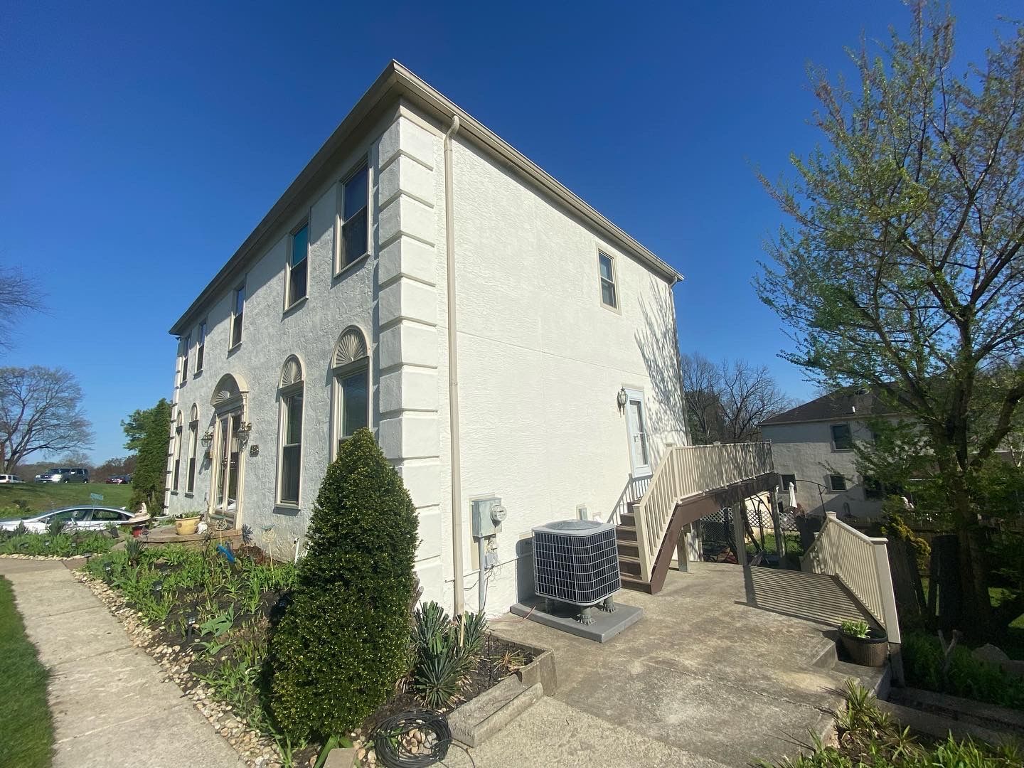A large white house with stairs leading up to the second floor