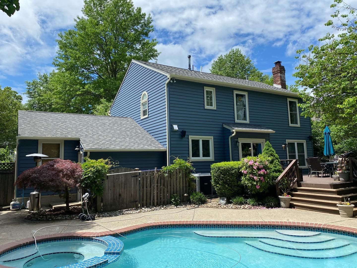 A blue house with a swimming pool in front of it