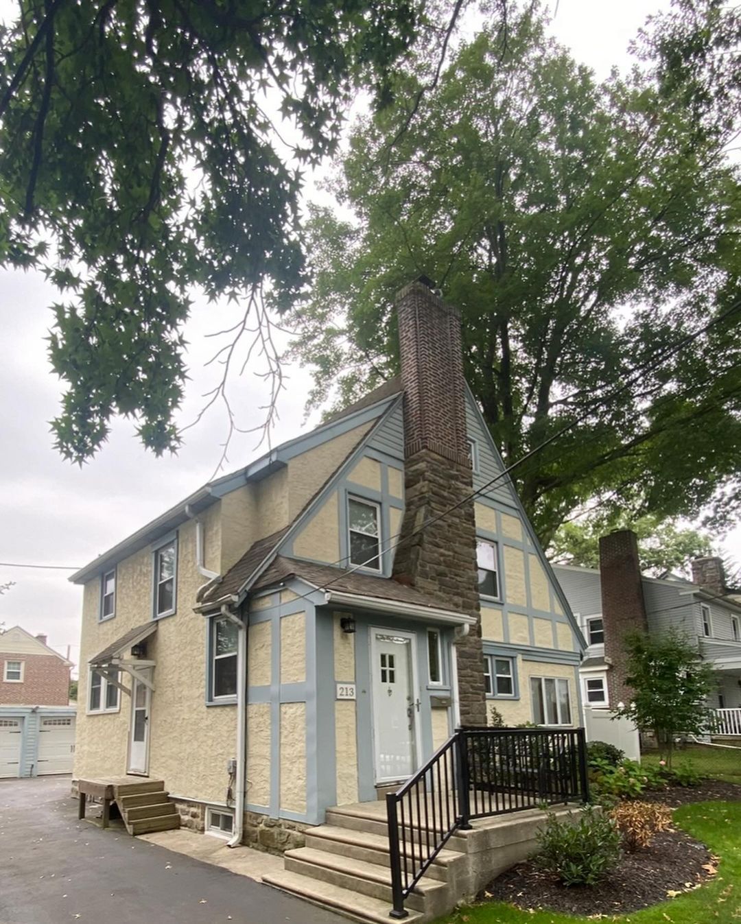 A house with a chimney on the top of it is surrounded by trees