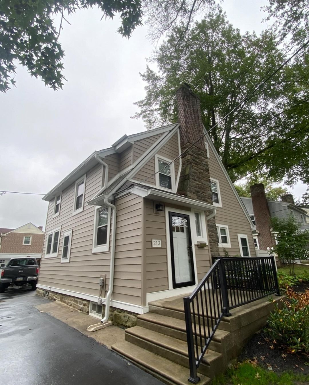 A house with stairs leading up to the front door and a chimney