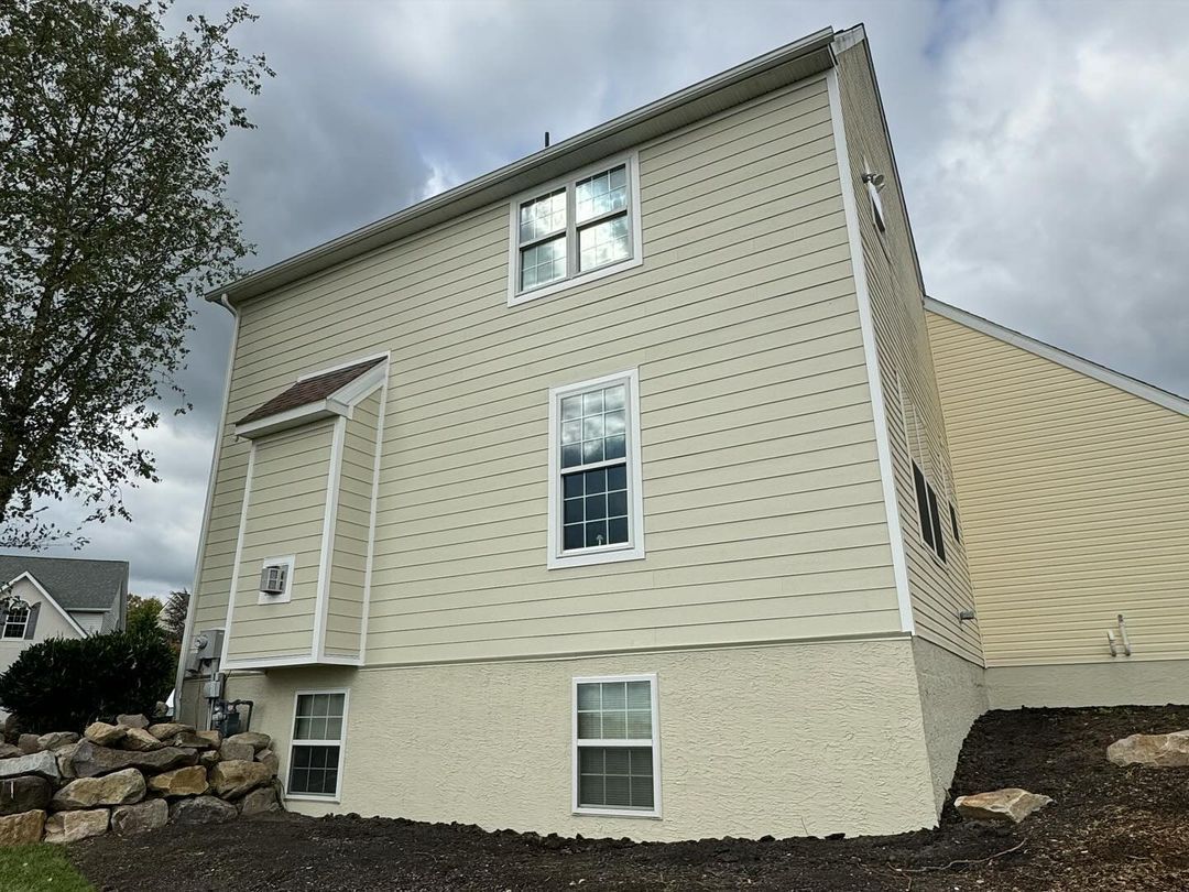 The back of a house with a lot of windows on a cloudy day