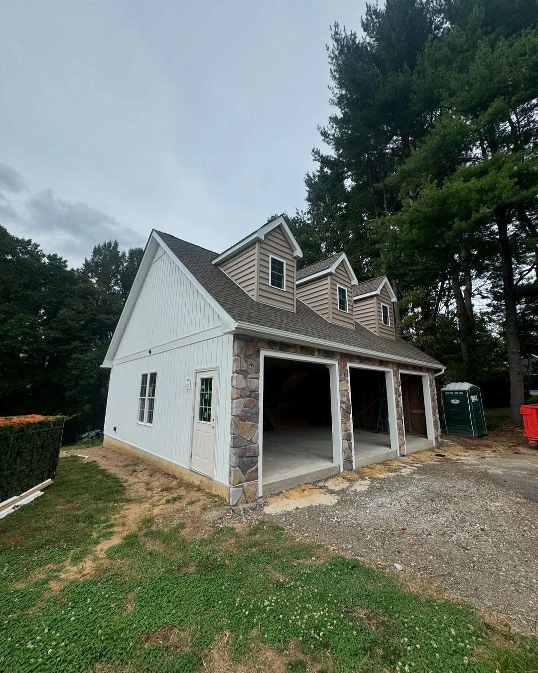 A white garage with two doors is being built in the backyard.