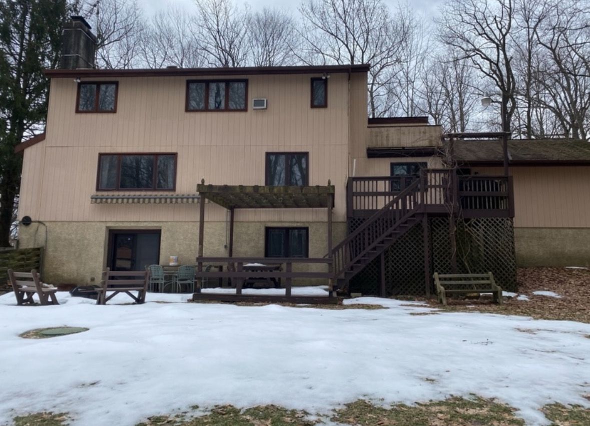 The back of a house with a deck and stairs- before