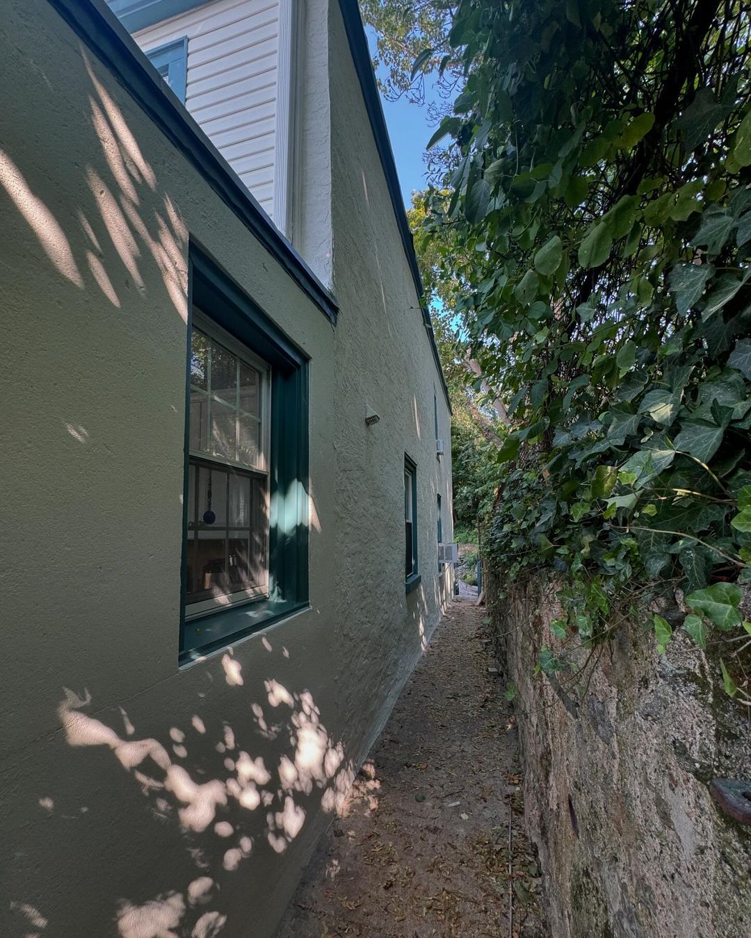 A house with a narrow alleyway leading to it.