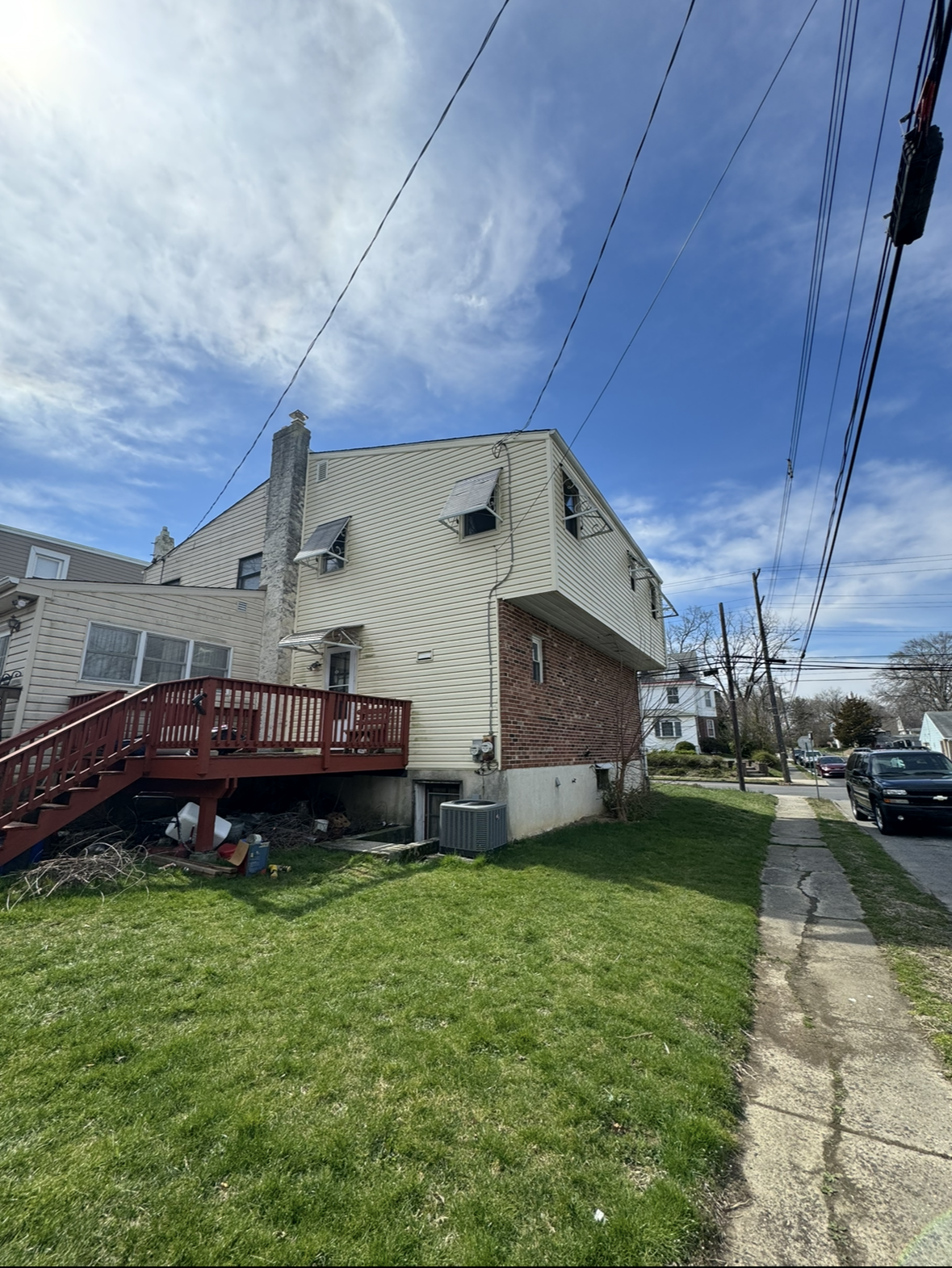 A house with a red deck and stairs on the side of it.