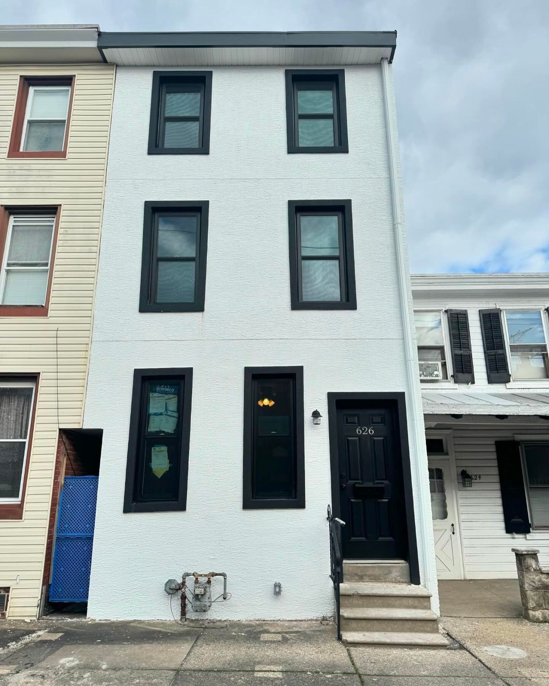 A white building with black windows and a black door.