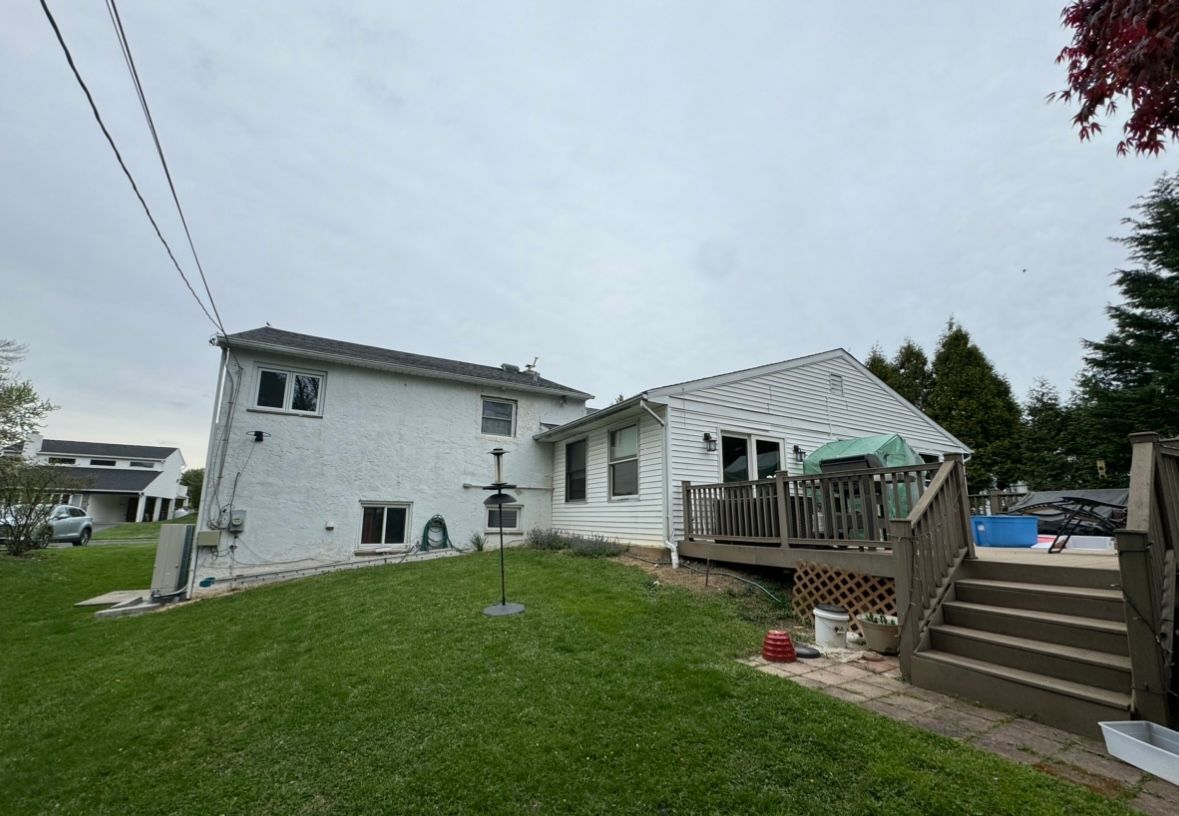 The back of a house with a deck and stairs- before