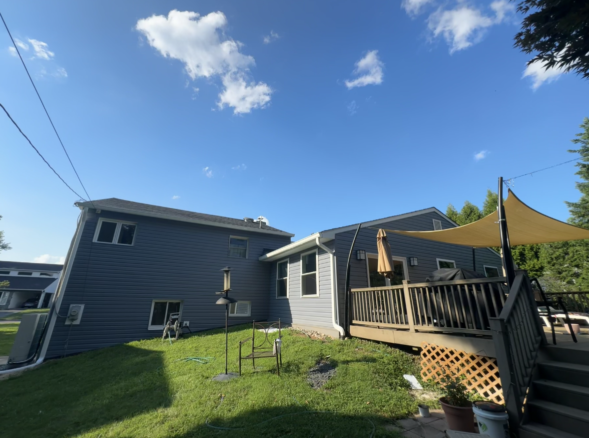 The back of a house with a deck and stairs- after