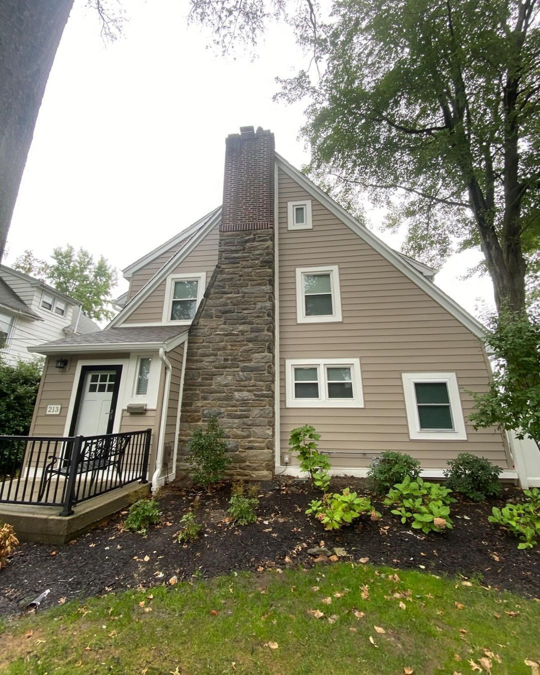 A house with a stone chimney on the side of it.