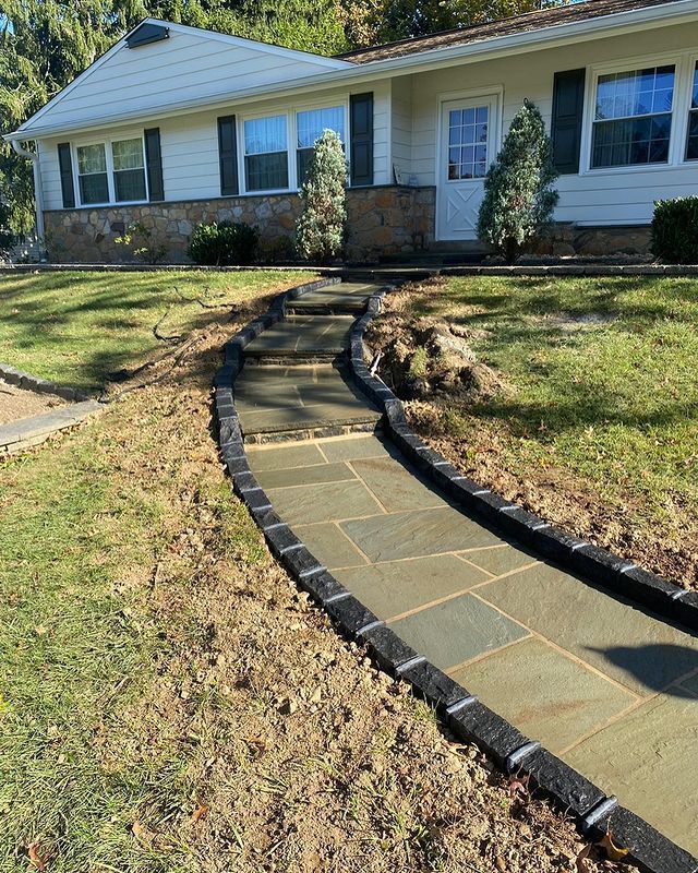 A stone walkway leading to a white house