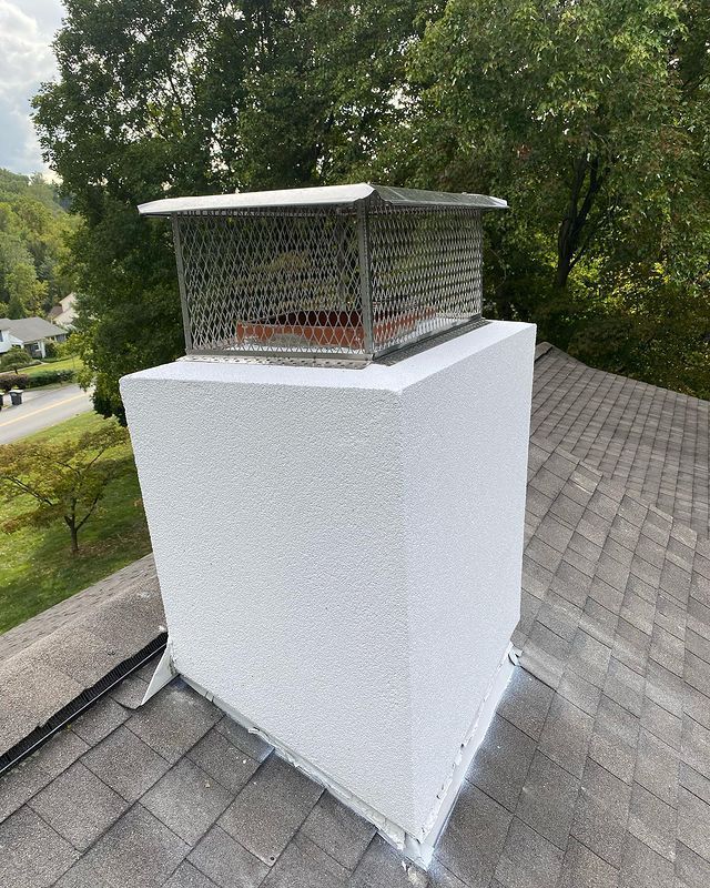 A white chimney is sitting on top of a roof.