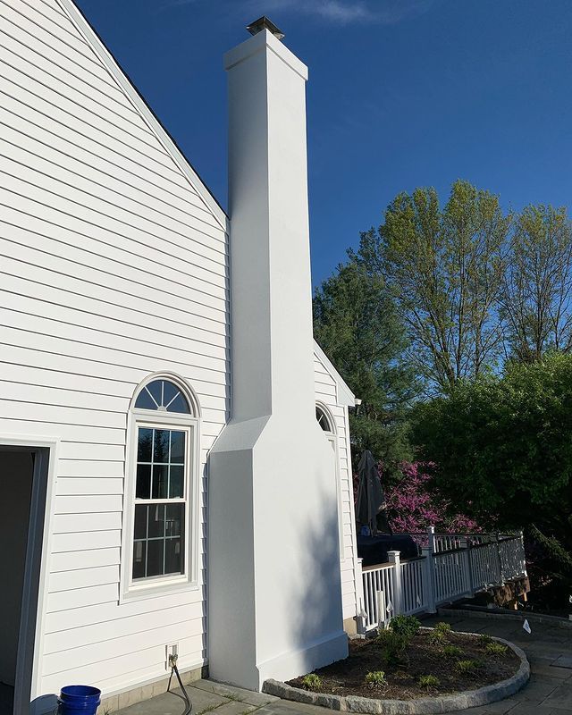 A white house with a large chimney on the side