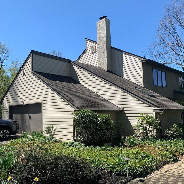 A house with a black truck parked in front of it