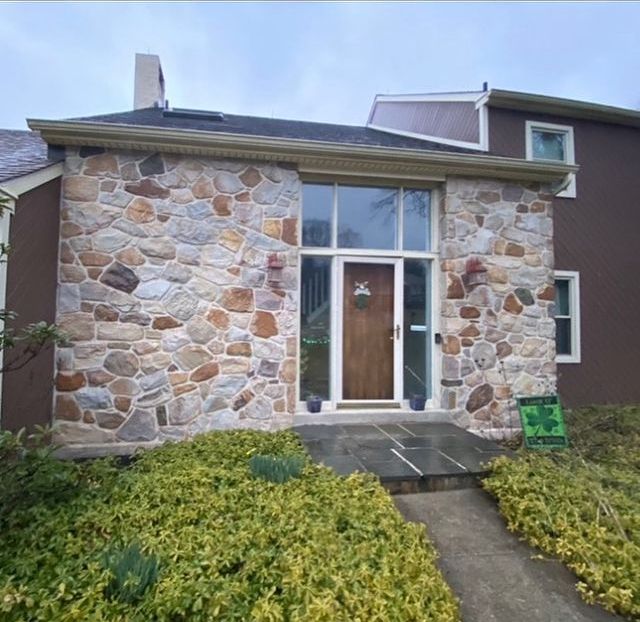 A brown house with a stone facade and a wooden door