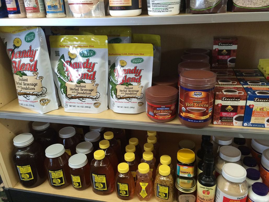 Shelves stocked with various food products: packaged mixes, jars of honey, sauces, and spices.