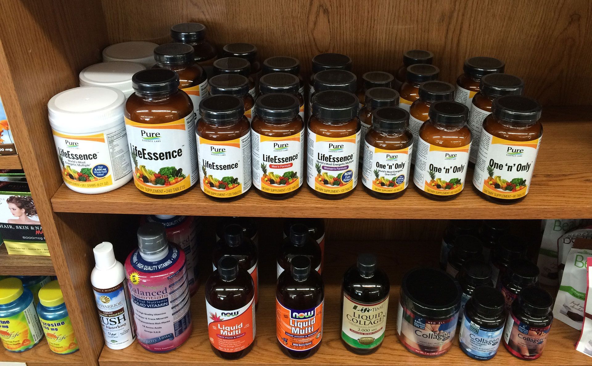 Bottles of supplements on wooden shelves in a store. Brown and white containers with dark lids.