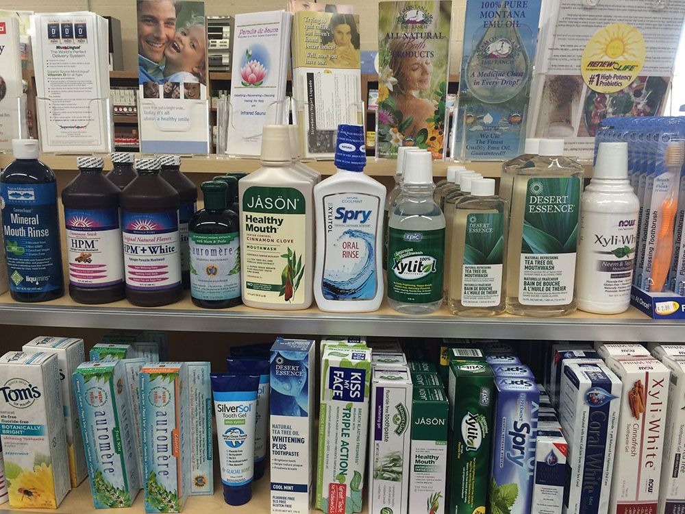Shelf of oral hygiene products in a store, including mouthwash and toothpaste.