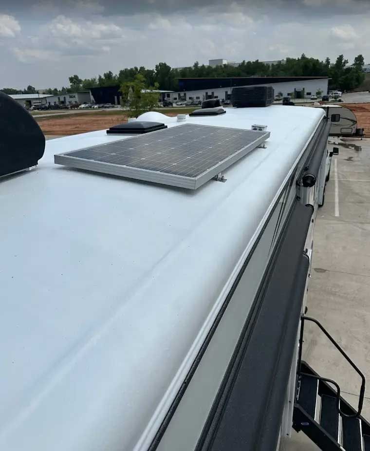A white rv with a solar panel on top of it