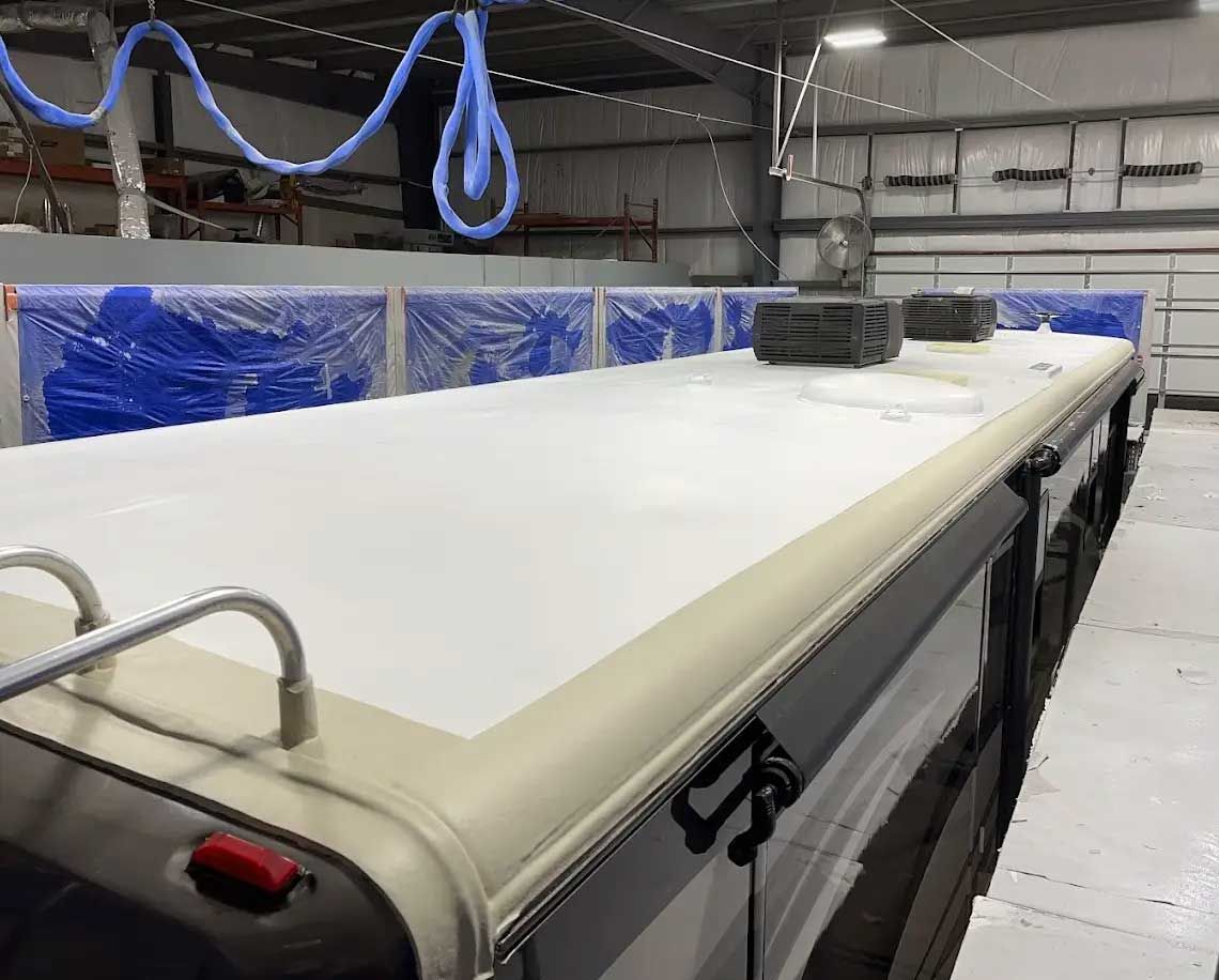 The roof of a bus is being built in a warehouse.