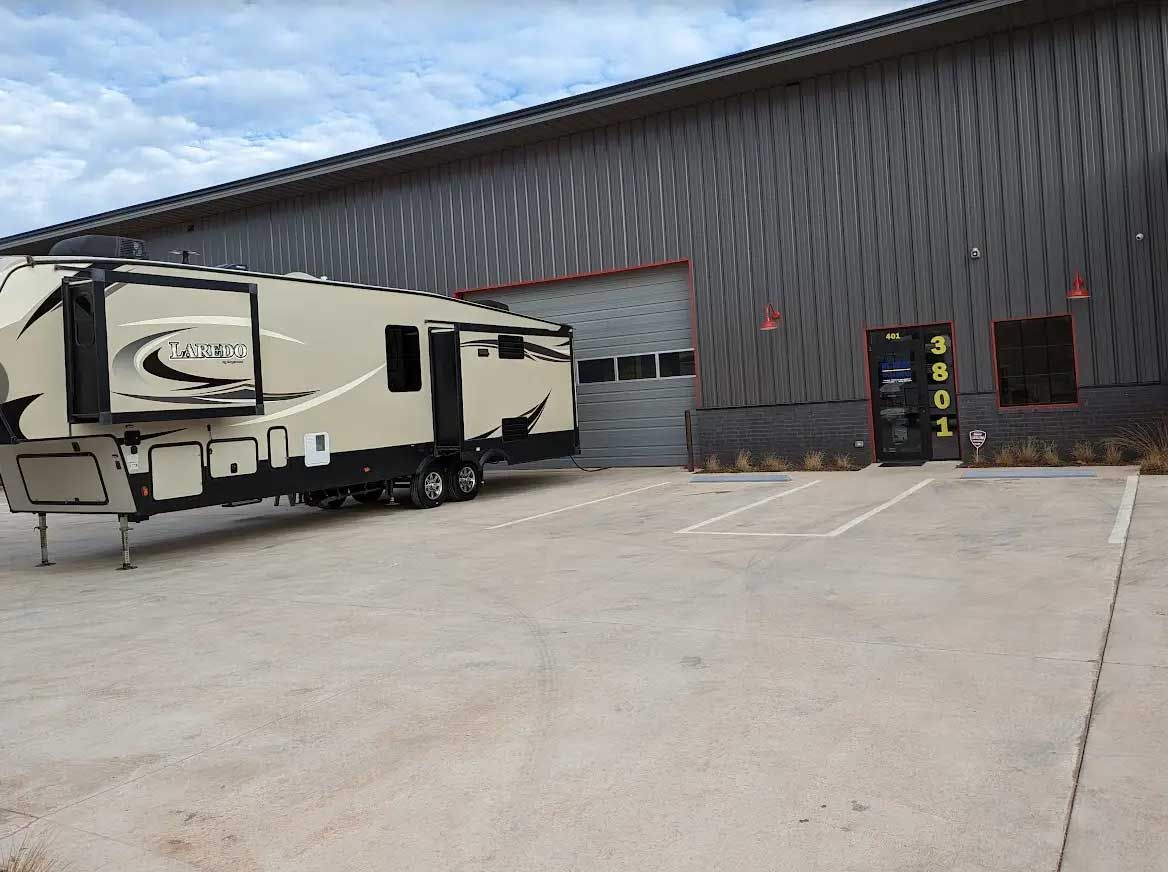 A trailer is parked in a parking lot in front of a building.