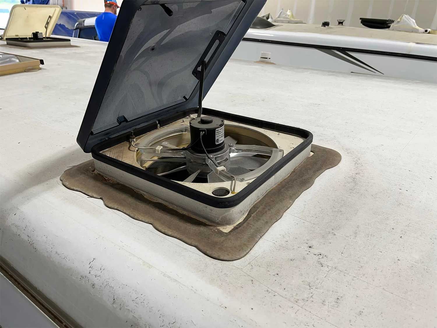 A fan is sitting on top of a white roof