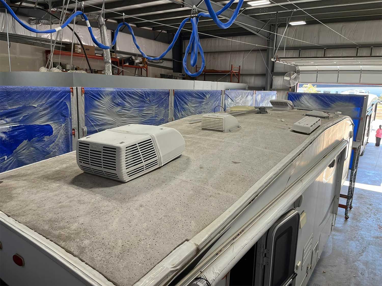 The roof of a trailer is being repaired in a garage.