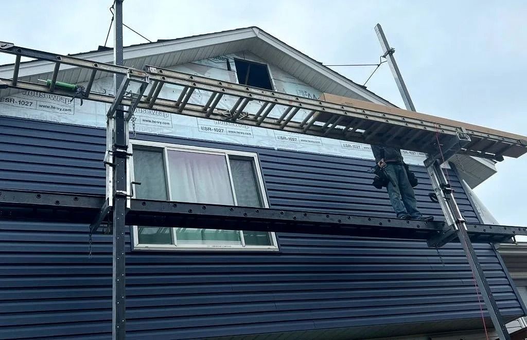 House with dark blue siding being installed on outside
