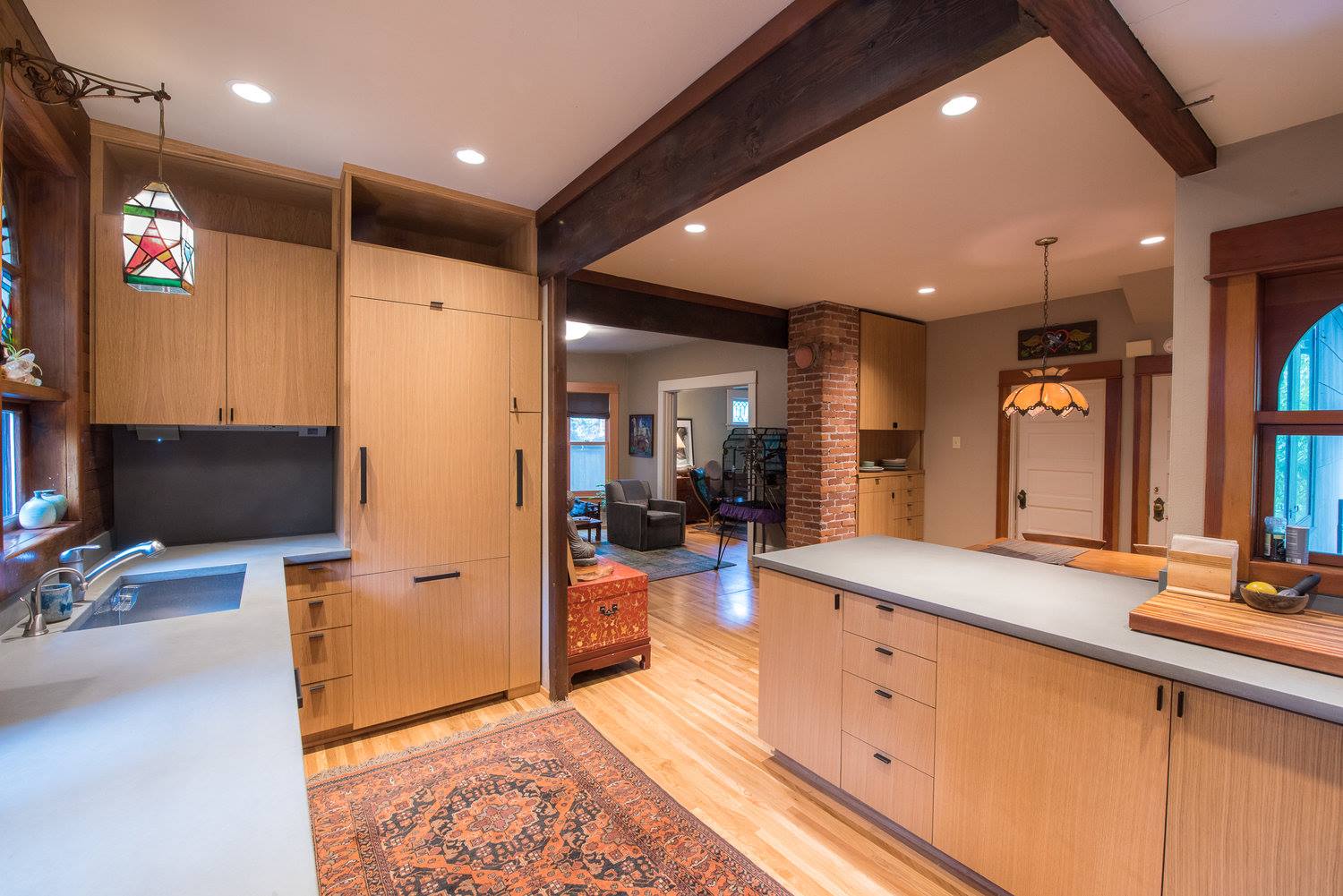 A kitchen with wooden cabinets and a rug on the floor.