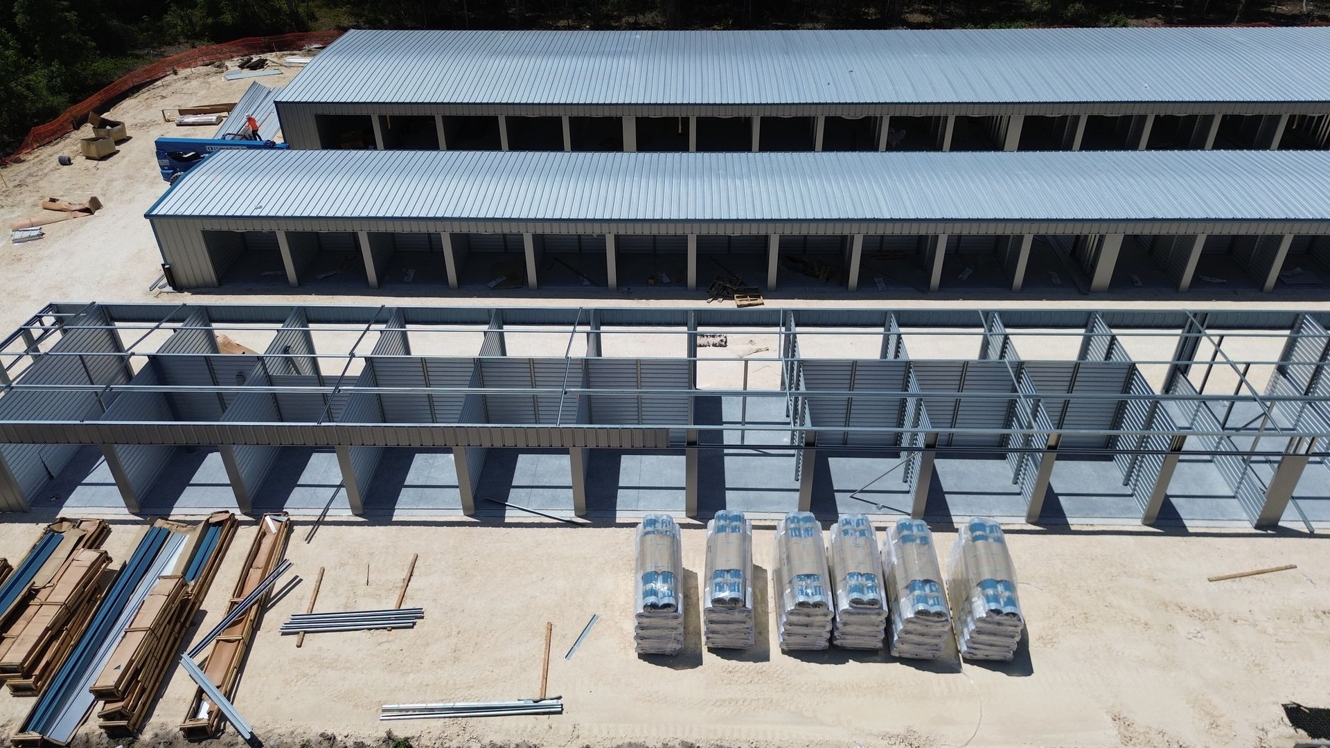 Aerial view of a modern building under construction with scaffolding and materials on the site