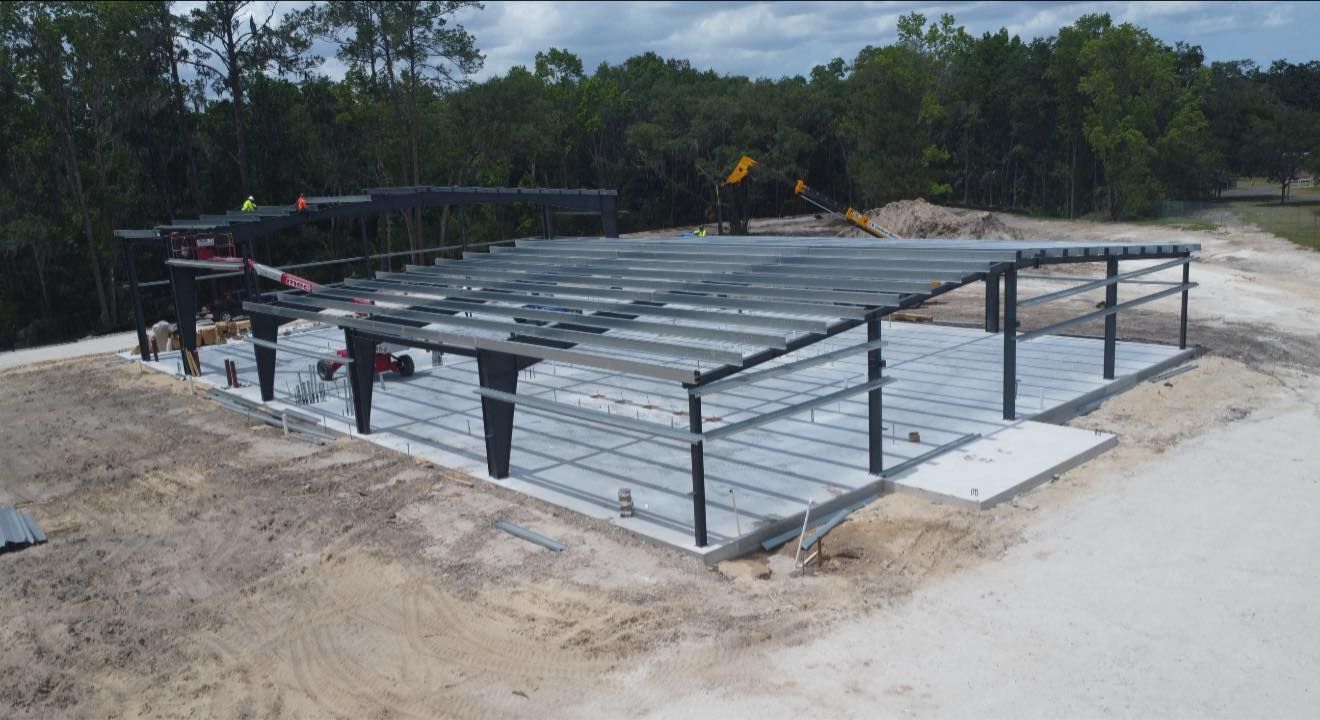 Concrete foundation with steel framing and rebar at a construction site under clear skies