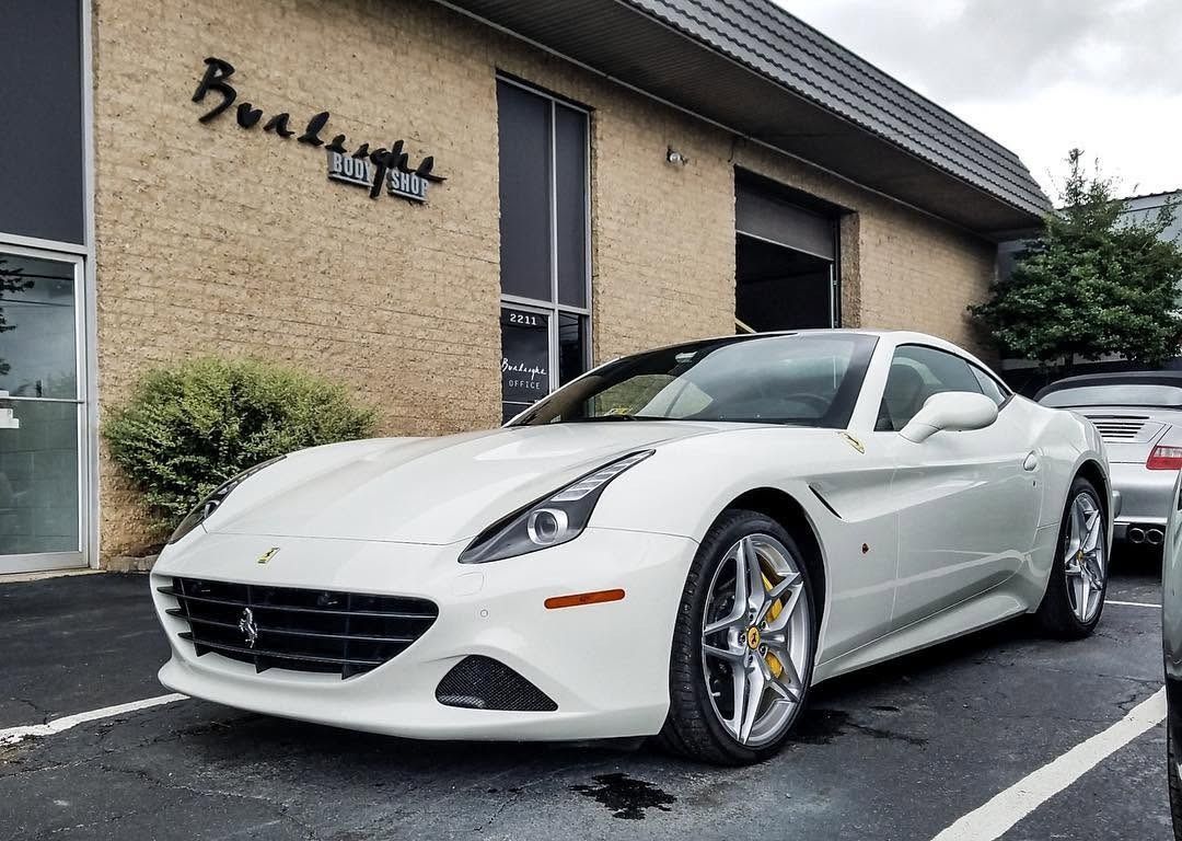 White sports car parked outside a building on a wet pavement