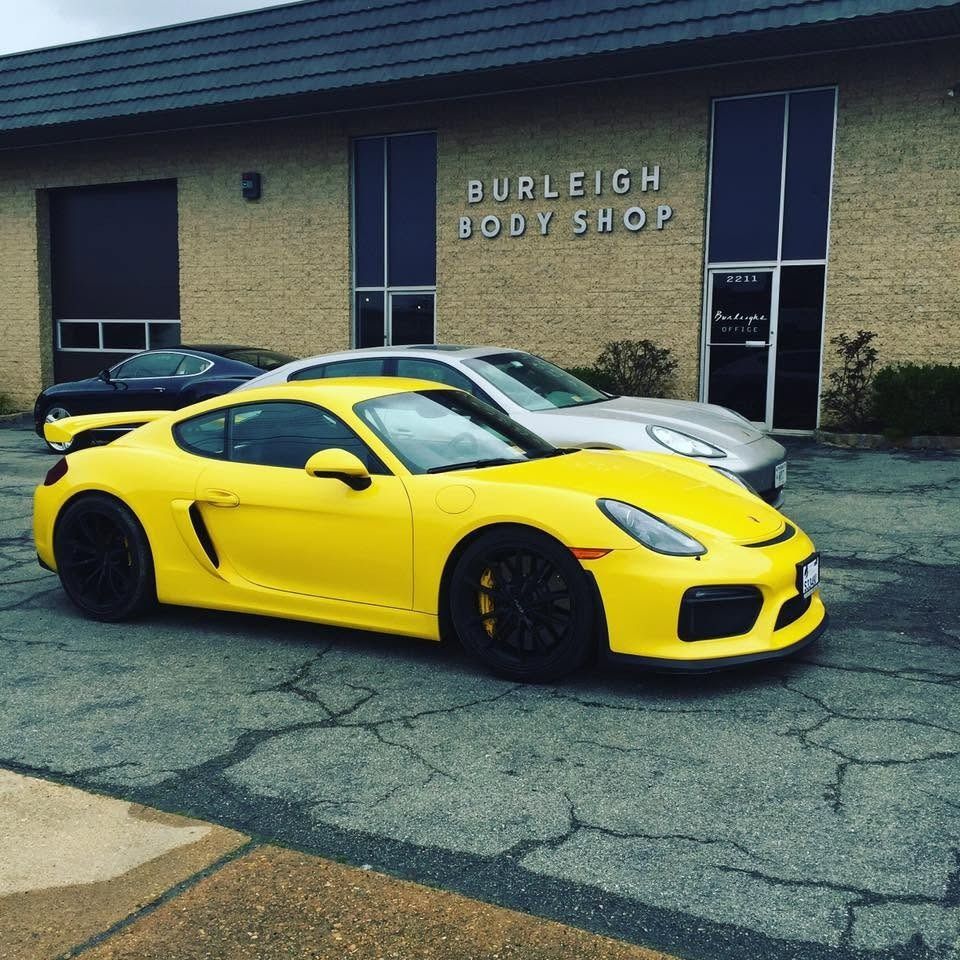 Yellow sports car parked outside Burleigh Body Shop with a silver car behind it