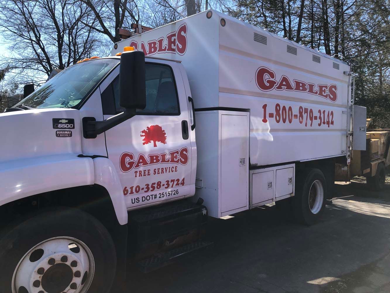 A white Gables Tree Service truck parked outdoors on a sunny day.
