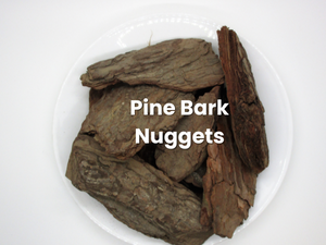 Pine bark nuggets piled on a white plate, labeled in white text